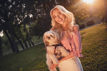 Photo of pretty cheerful girl hands hold cute doggy enjoy nice warm weather street outdoors