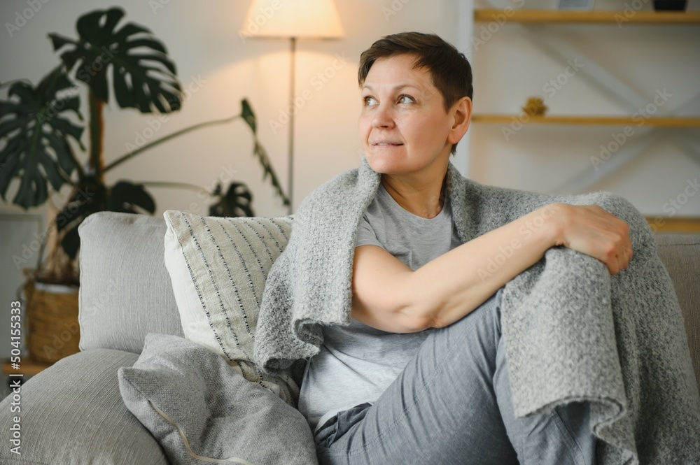 Wall mural attractive middle aged woman relaxing at home.