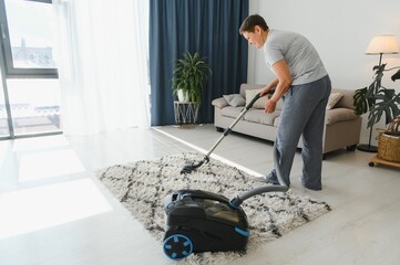 Fototapeta premium Middle-aged woman cleaning new apartment.