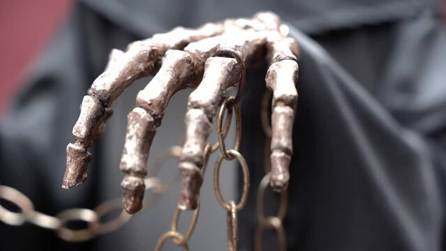 Bones of a hand holding a chain