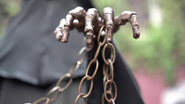 Hand of a skeleton holding a chain