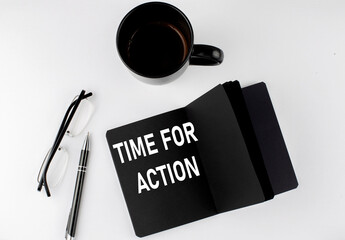 TIME FOR ACTION written text in small black notebook with coffee , pen and glasess on white...