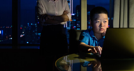 Mother with son doing homework on laptop