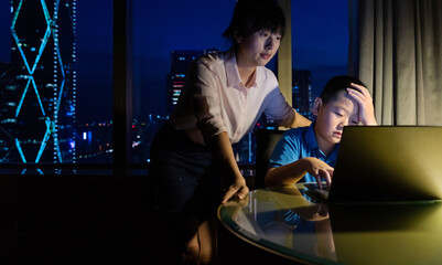 Mother with son doing homework on laptop
