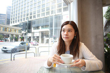 woman have a tea in the cafe inside the busy city