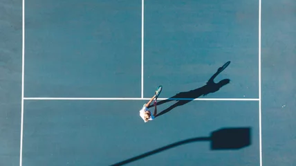 Directly above view of young caucasian female player playing on blue tennis court during sunny day © WavebreakMediaMicro