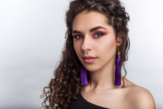 Elegant and gental pretty young woman with professional makeup curly volume hairstyle and nose and ears piercing
