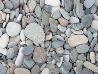 Big stones on the beach. Background from stones. Boulders on the seashore. Smooth cobblestones.