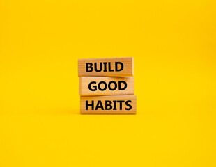 Build good habits symbol. Wooden blocks with words 'Build good habits'. Beautiful yellow background. Business and 'Build good habits' concept. Copy space.