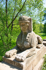 Fototapeta na wymiar A bridge with sphinx statue. Veltrusy chateau. Czech Republic.