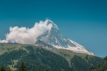 Zermatt's famous Matterhorn (4.478 m) with a banner cloud attached to it rising above Zermatt in...
