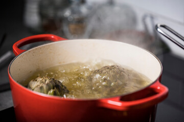 Artichokes boiling in a pot.