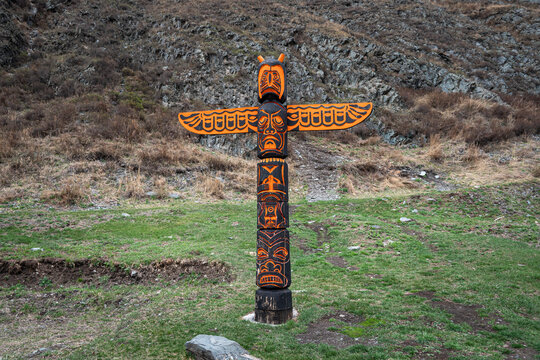 Totem pole with eagle and wings against background of nature