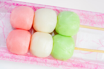 Sweet Three Coloured Sanshoku Dango Dumplings on white background, Dango Japanese traditional sweet snack.