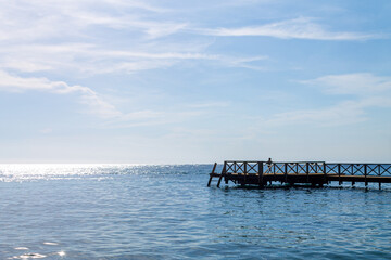 Fototapeta premium Little girl is playing on the dock.