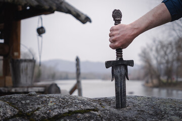 famous sword excalibur of King Arthur stuck in rock. Edged weapons from the legend Pro king Arthur.