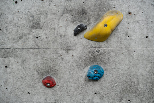 Rock climbing wall with climbing holds in gym