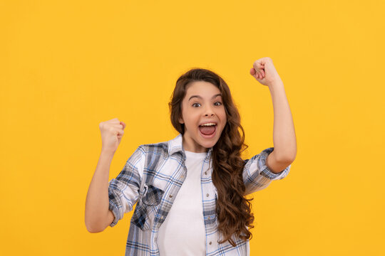 glad teen kid in checkered shirt with long curly hair on yellow background