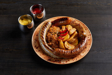 Closeup view of grilled sausages served with fried potato
