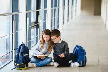 School kids with books together in corridor. Conception of education.
