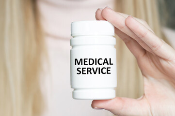 Medicine and health concept. Medical Service text on the label of the jar in the hands of the girl brewch
