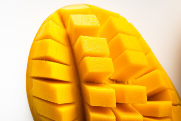 Juicy ripe yellow Thai mango on a white background. Hard light and shadow from a palm tree.