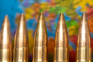 Cartridges with bullets on the background of the world map. Concept: war in Ukraine, armed...