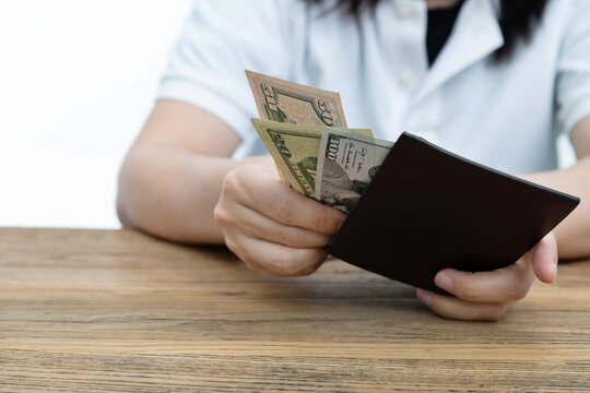Woman hand holding a leather wallet with dollars