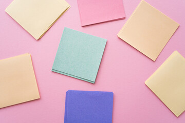 top view of colorful and blank paper notes on pink.