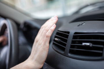 woman adjusting the cooling inside her car, Closeup of hand driver checking adjusting air from conditioning the cooling system with flow of cold air in car.