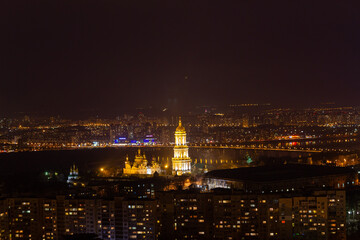 Fototapeta premium Ukraine, Kyiv – March 12, 2016: Aerial panoramic view on Kyiv Pechersk Lavra and central part of Kyiv city. Night life in a big city. Dnipro river. 