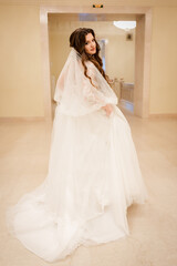 Charming happy bride with long veil. marble staircase