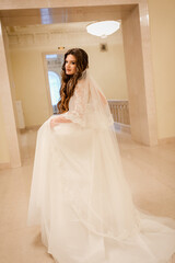 Charming happy bride with long veil. marble staircase