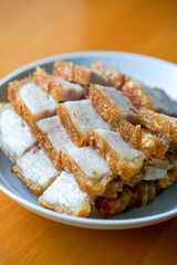 Close-up of a plate of golden and attractive crispy roasted pork, with meat
