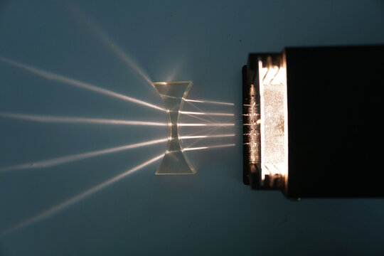 Parallel beams from the light box are refracted through a concave lens. Optical physics experiment.