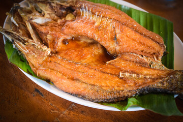 fried fish on dish with table wood background