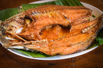 fried fish on dish with table wood background