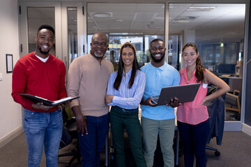 Portrait of smiling biracial advisor's team in boardroom during meeting at modern workplace