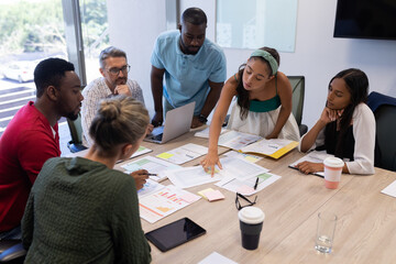 Multiracial advisors discussing over strategy at conference table in boardroom during meeting