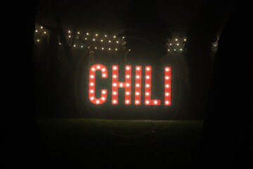 Neon sign in mute on the grass.