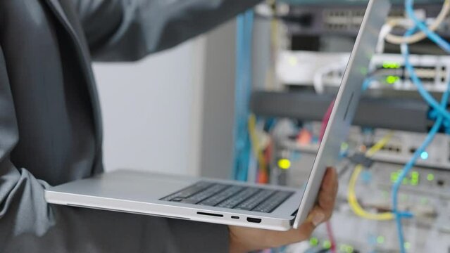 Male administrator it engineer conducts maintenance work in secure server room of cyberspace