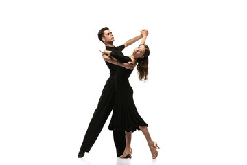 Twee jonge sierlijke dansers dragen zwarte podium outfits dansen ballroom dans geïsoleerd op een witte achtergrond. Concept van kunst, schoonheid, muziek, stijl.