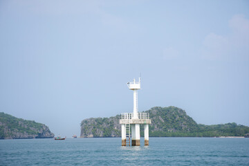 Fototapeta na wymiar Classic vintage lighthouse or beacon in sea ocean for security protection of fishing boat and fishery ship sailing at Mu Ko Petra National Park in Pak Bara waterfront at La ngu city in Satun, Thailand