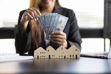 Real estate agent businesswoman counting cash, deposit or commission on real estate sales. - obrazy, fototapety, plakaty