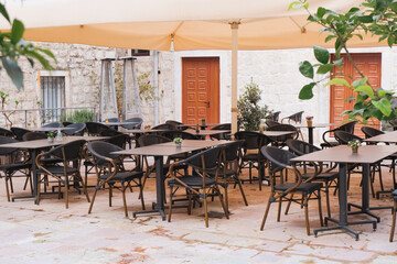 Fototapeta na wymiar retro style tables and chairs at cafe outdoor terrace, vintage atmosphere, dining time, relax and leisure patio concept