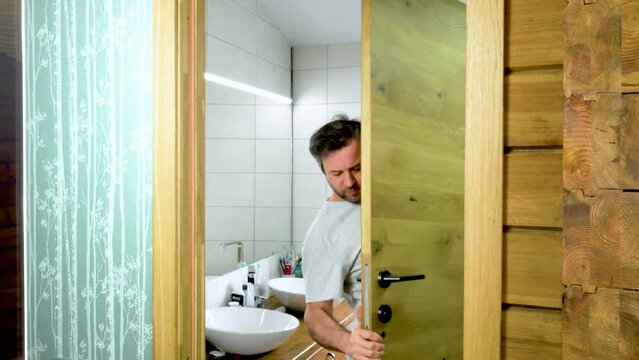 The master removes a wooden door, in a bathroom in a modern wooden house. Preparing a wooden interior door for installation in a bathroom in a wooden house. High quality 4k footage