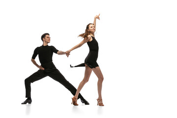 Dynamic portrait of young emotive dancers in black outfits dancing ballroom dance isolated on white background. Concept of art, beauty, music, style. - obrazy, fototapety, plakaty
