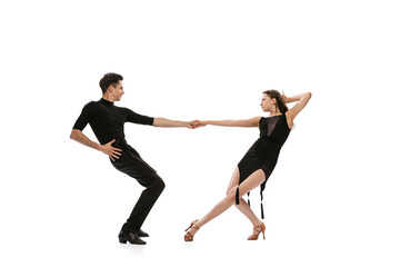 Fototapeta premium Dynamic portrait of young emotive dancers in black outfits dancing ballroom dance isolated on white background. Concept of art, beauty, music, style.