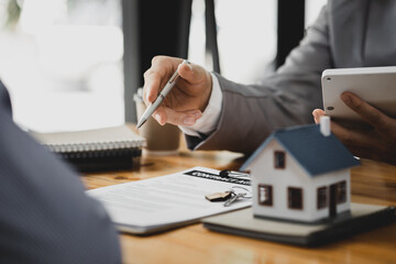 Rental company employee is discussing the details before the customer agrees to sign a rental contract, explaining the details and the terms and conditions of the rental. Real estate rental ideas.