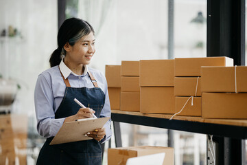 The owner of an online store is checking orders for packaged products in order to prepare them for...